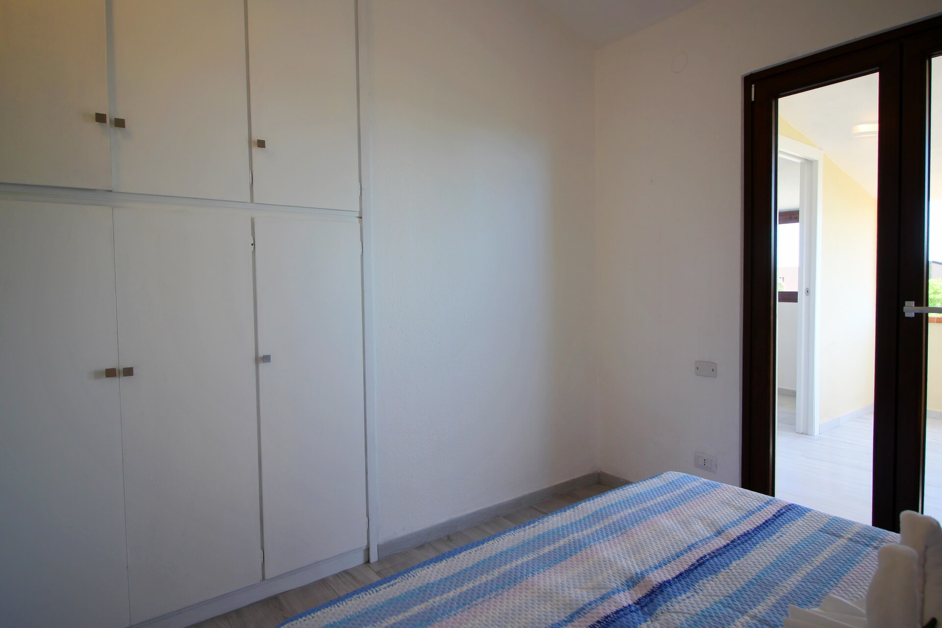 Armadio bianco a muro in camera da letto con accesso alla veranda