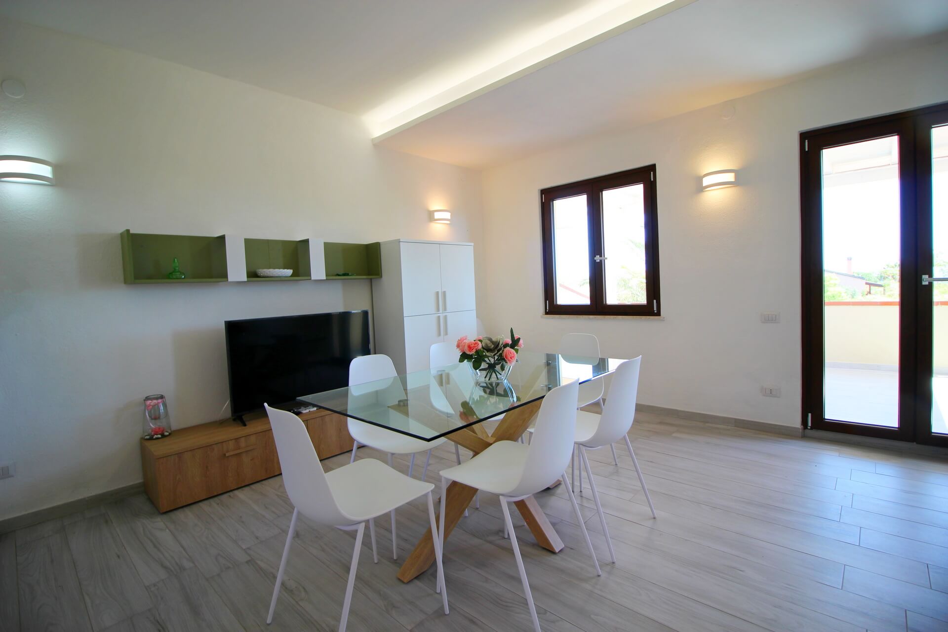 Soggiorno spazioso e luminoso con tavolo da pranzo e sedie moderne