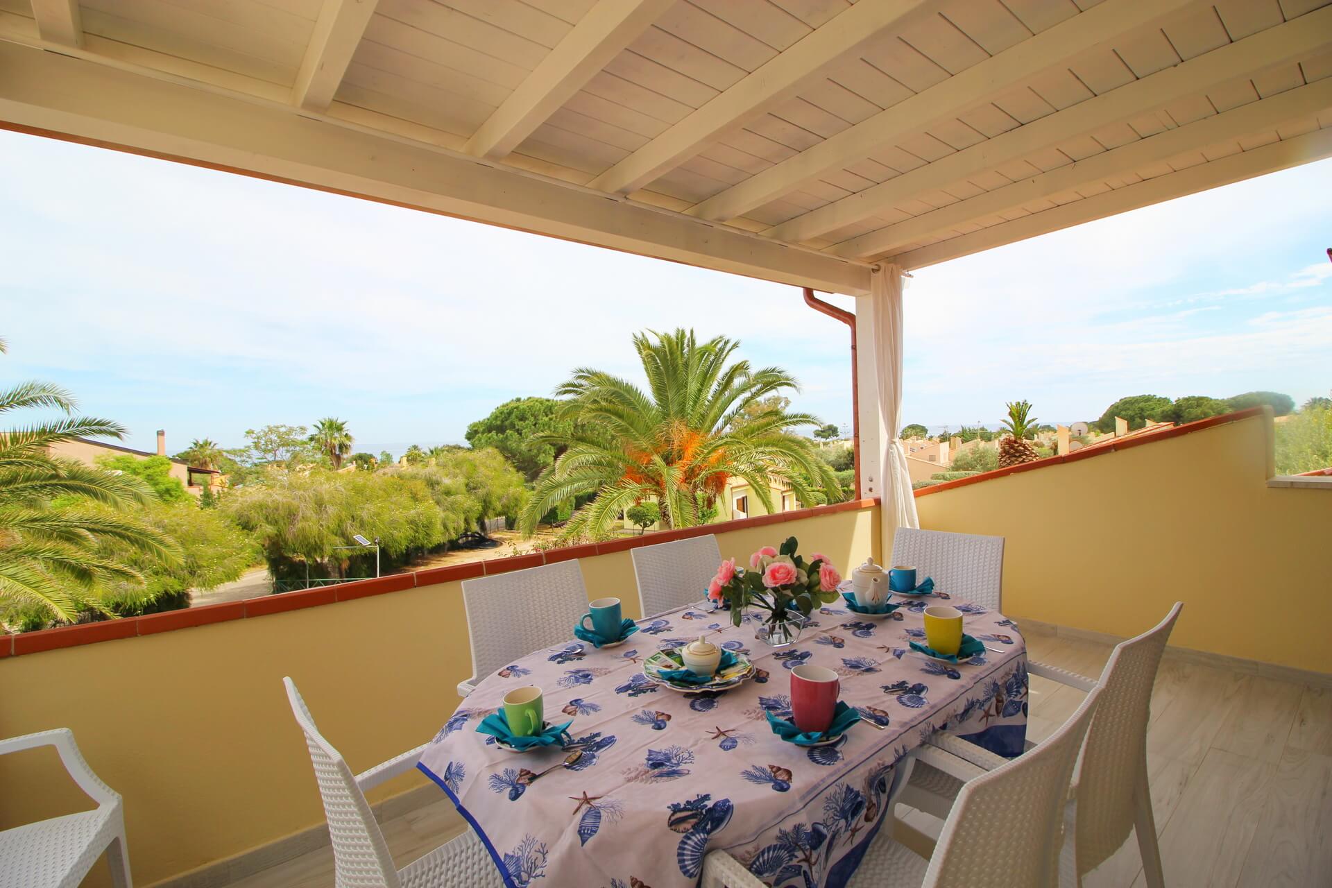 Tavolo apparecchiato sulla veranda della Casa Corina con vista sulla vegetazione